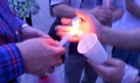 Lighting candles at dusk before the start of the 19th candle parade