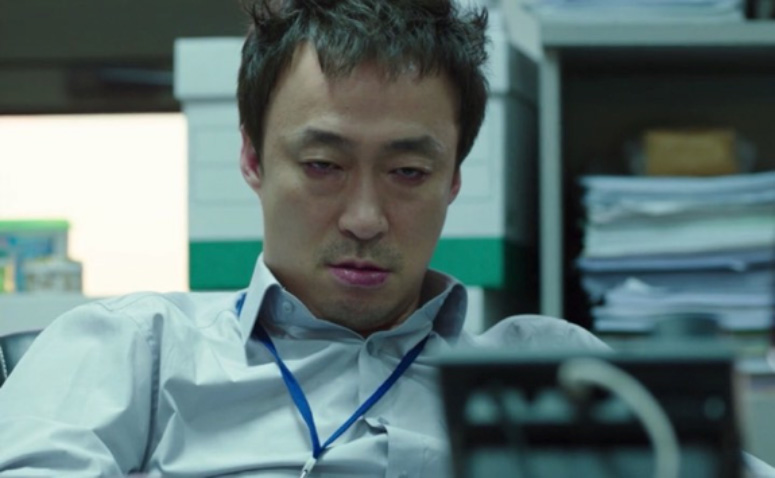 Oh Sang-Sik from the TV series Misaeng sitting at his desk tired