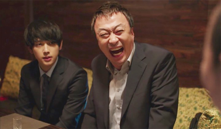 Oh Sang-Sik from the TV drama Misaeng forcing a laugh 