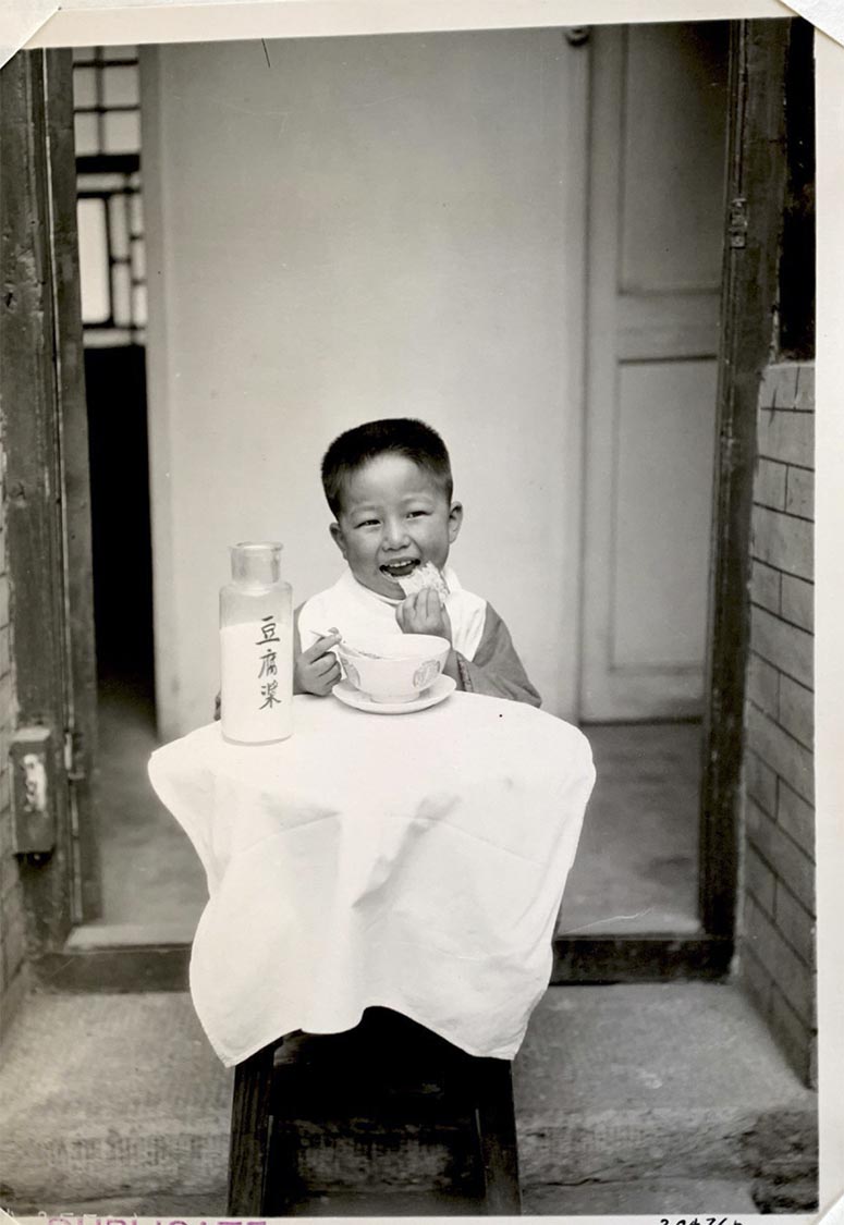 Child about to take a bite of their meal, sitting down at a table with a bowl and milk 