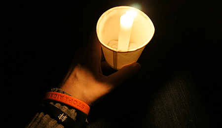 Single candle, held by a participant, at the end of the parade